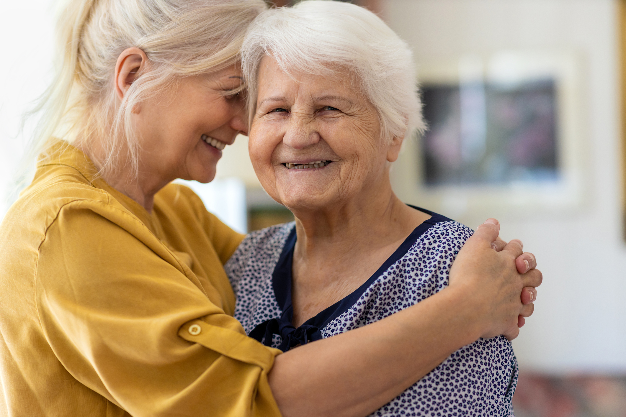 Mujer abrazando a su madre anciana